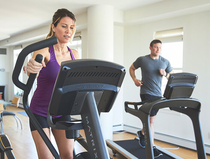 Man and woman working out on Matrix cardio equipment