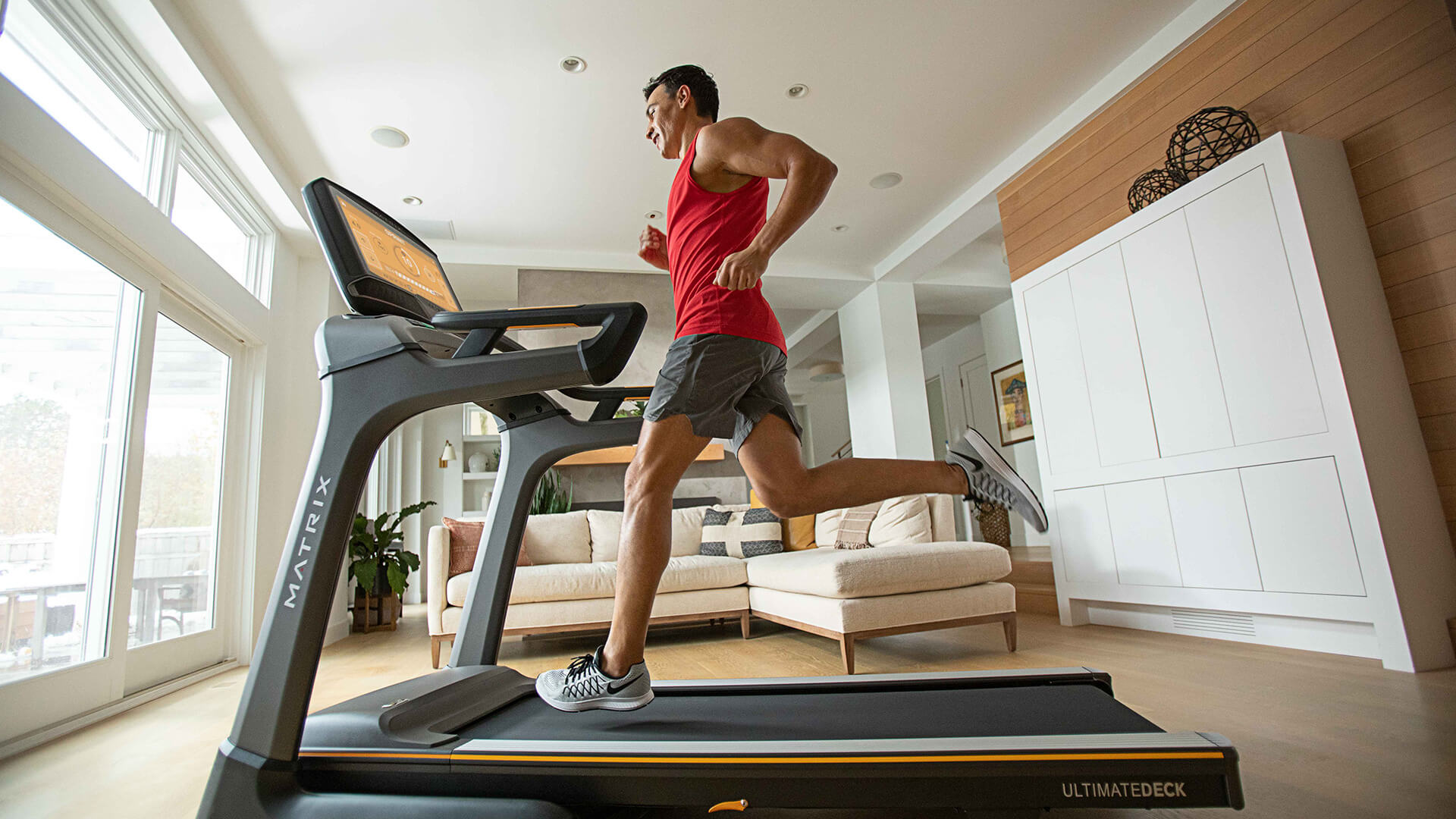 Man running on a residential Matrix treadmill in living room