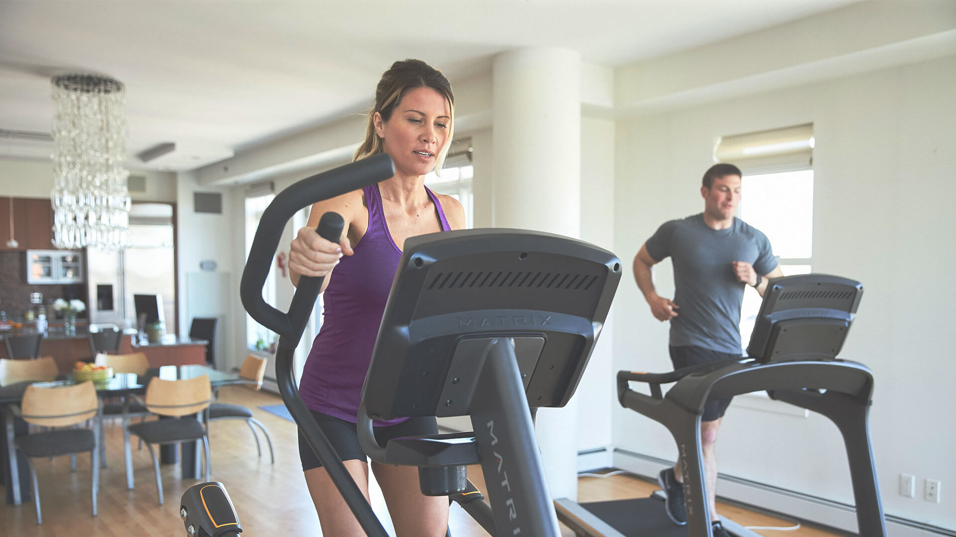 Man and woman working out on Matrix cardio equipment in home