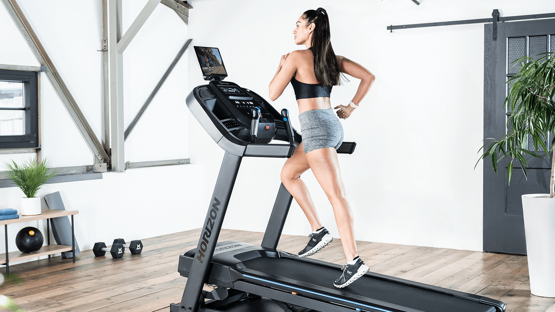 Woman running on Horizon treadmill in home