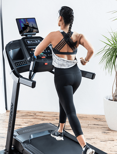 Woman running on Horizon treadmill using Treo app on tablet