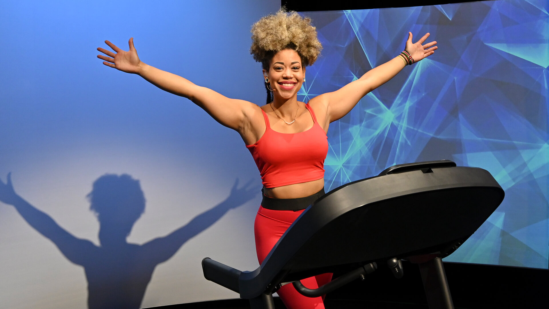 Woman running on Horizon treadmill, celebrating workout