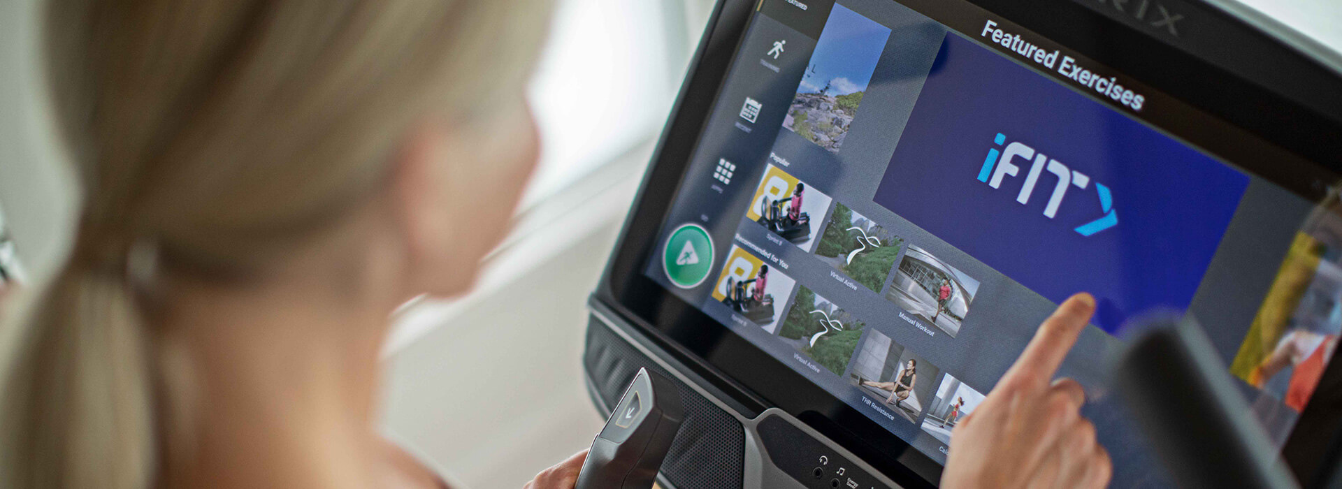 Woman interacting with iFIT app on Matrix XUR console